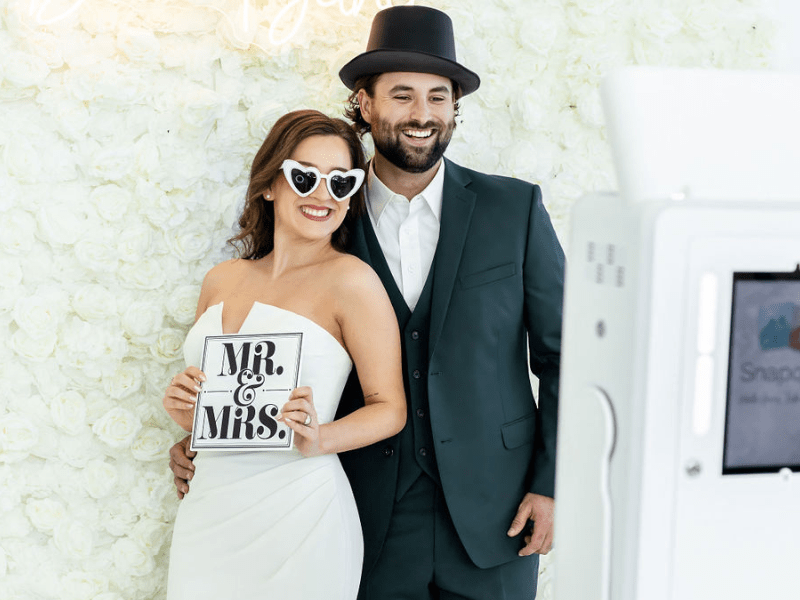 bride and groom taking picture in wedding photo booth rental