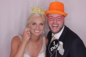 bride and groom in wedding reception photo booth with photo props in Virginia Beach