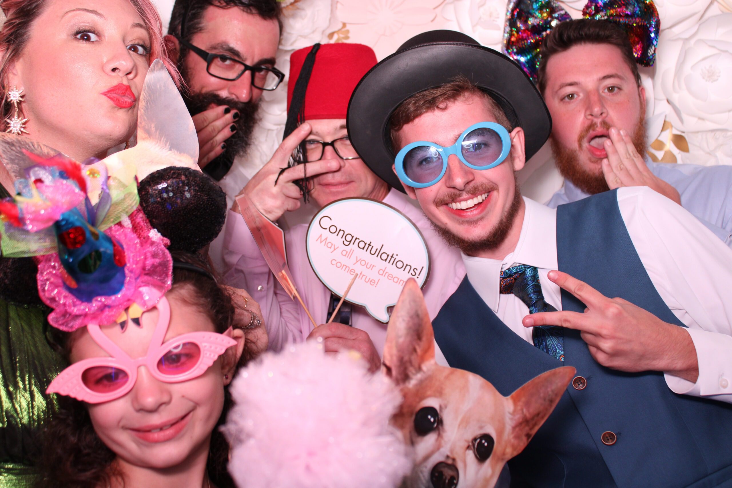 guests in wedding photo booth posing with props