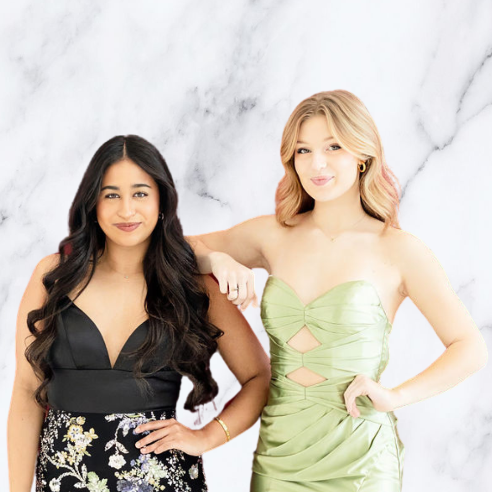 two teenage girls in party photo booth in front of marble backdrop