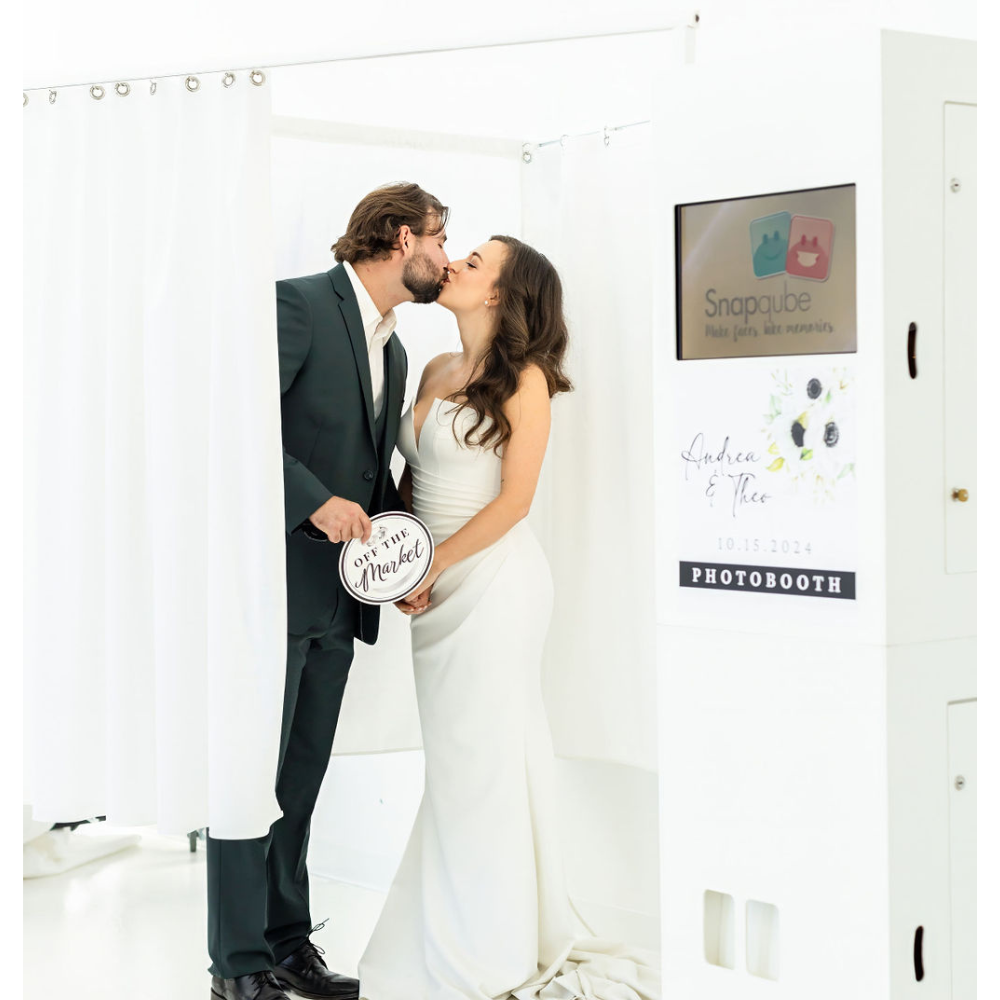 enclosed wedding photo booth rental with bride and groom kissing