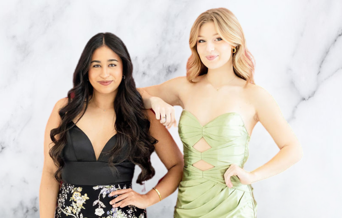 two young girls posing in front of white and gray marble photo booth backdrop in evening gowns for corporate event