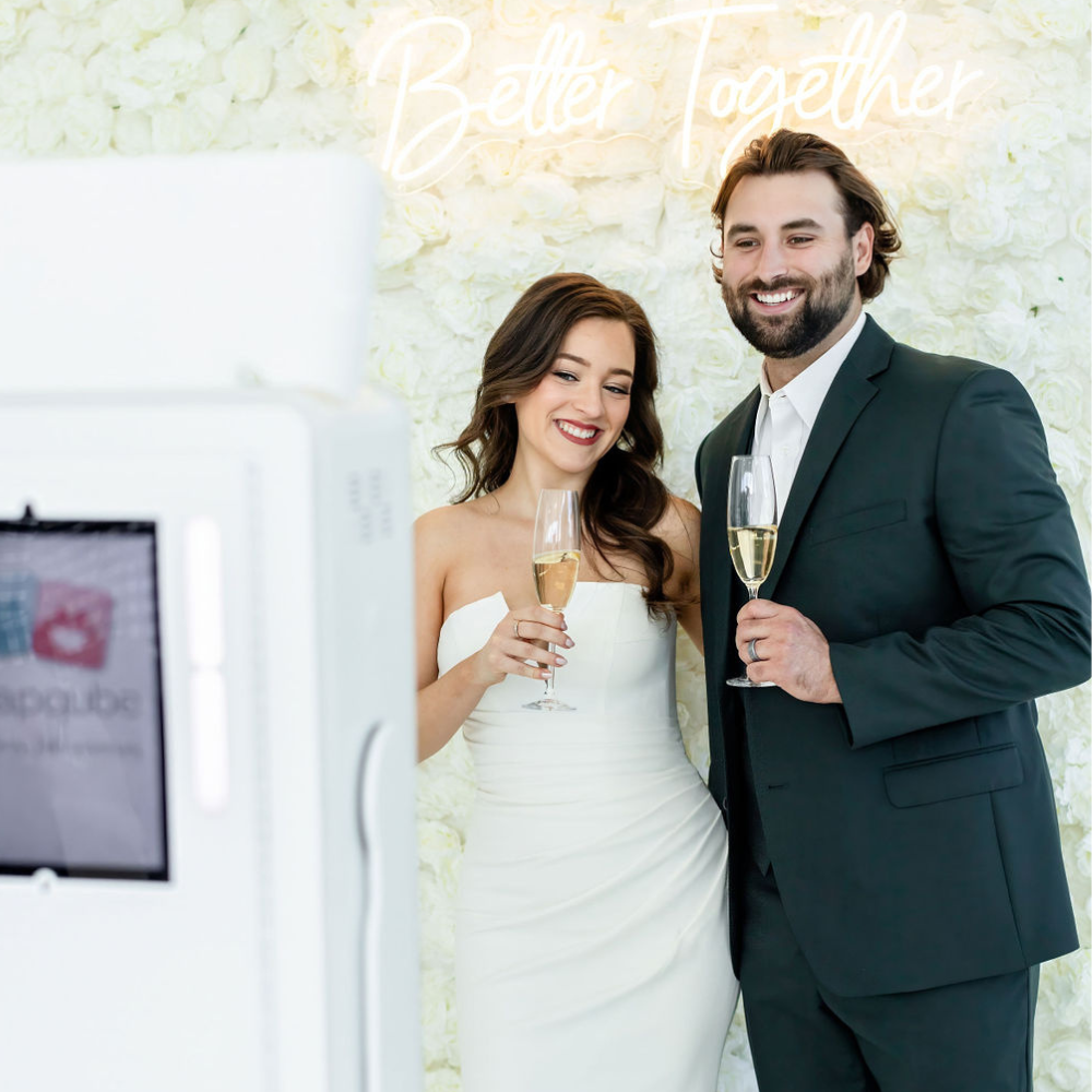 bride and groom wedding photo booth white flower wall with neon sign