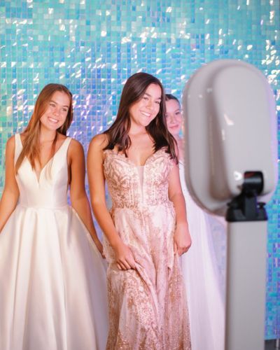three teen girls posing with Snapqube prom digital photo booth with blue backdrop