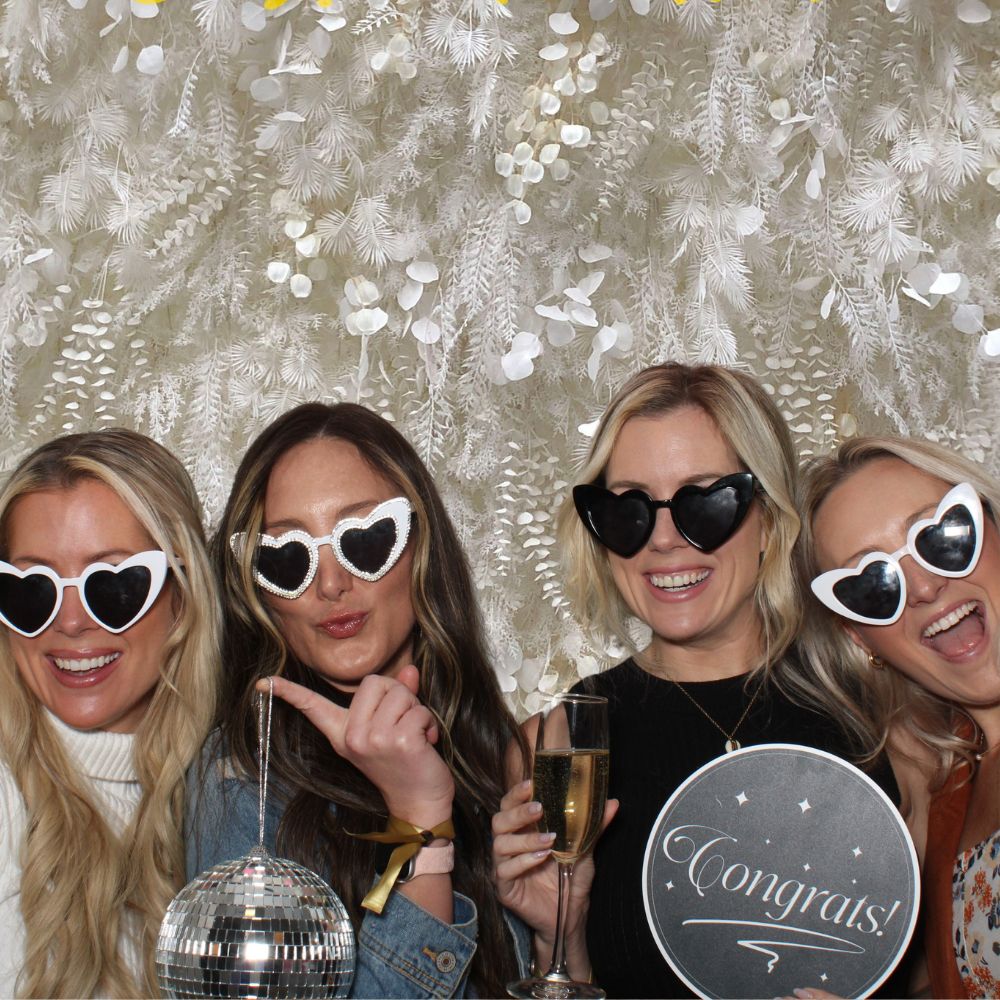 boho-background-bridal-popup(1000 x 1000 px) four brides to be posing in front of boho chick white backdrop wearing heart sunglasses in open air photo booth rental
